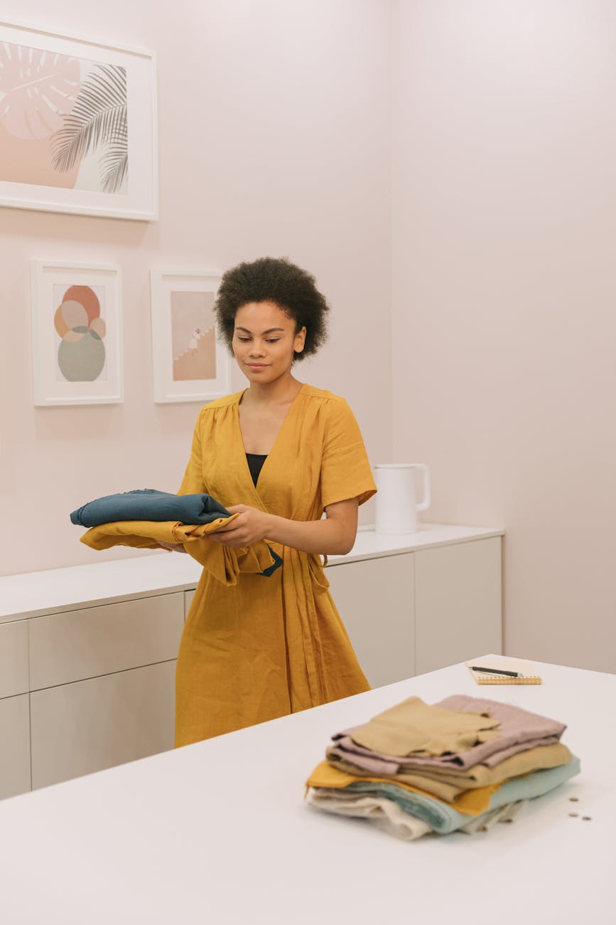 a woman in yellow dress holding folded clothes